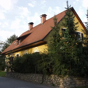 Wohnhaus mit steilem roten Ziegeldach und zwei Kaminen