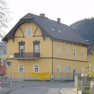 Gebäude mit grauem Mansarddach und mehreren Dachgauben