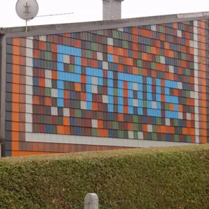 Fassade aus farbigen Platten, zu einem Mosaik mit dem Schriftzug Primus gesetzt